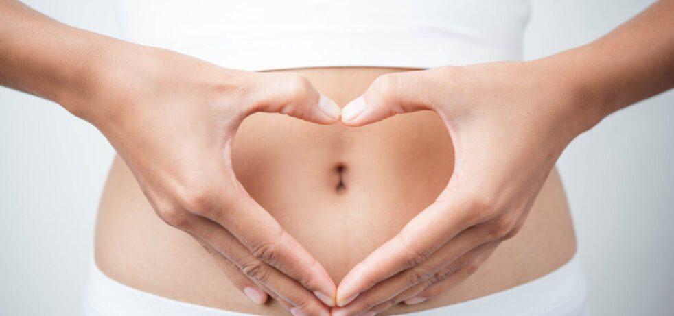 Close up of woman's hands made heart on belly isolated on white background.health care concept.